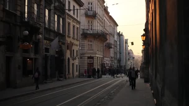 Die schöne Aussicht auf die Stadt mit antiken Gebäuden und die Straße voller Menschen. der Sonnenuntergang. — Stockvideo