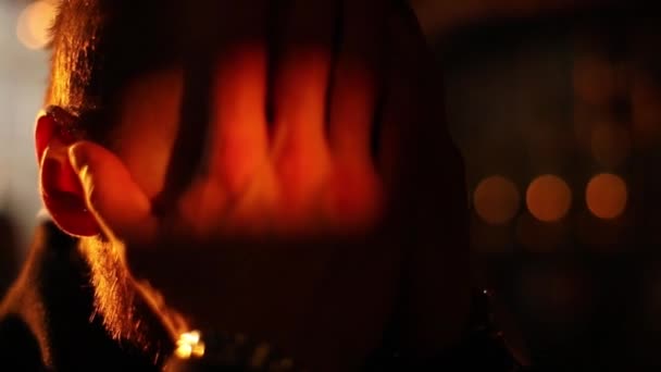 Le côté rapproché de l'homme déprimé fermant son visage avec les mains et les gardant dans le signe pour la prière à l'arrière-plan du coucher de soleil lumineux .