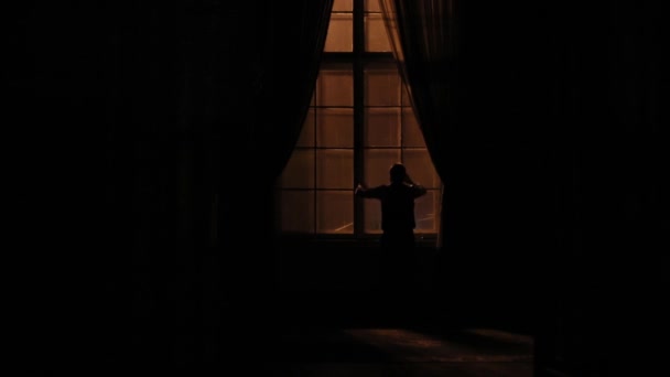 Вид ззаду депресивного чоловіка, який б'є у вікно у темній кімнаті . — стокове відео