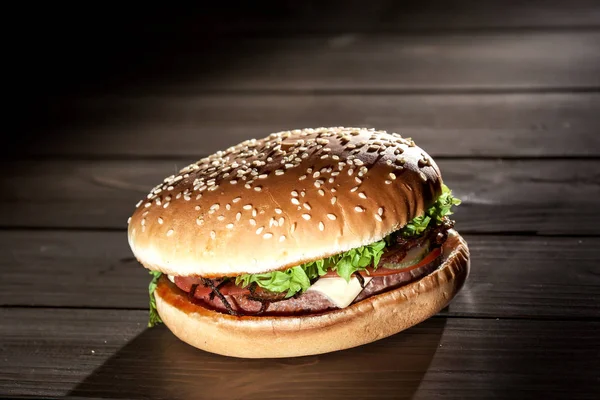 Zbliżenie smaczne burger z sezam bułka. Burger z mięsa, sera i warzyw. — Zdjęcie stockowe