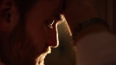 Karanlık odada pencereden bakarak sakal IR ile depresif adam. Yakın çekim portre.