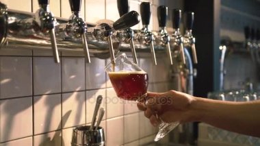 Barmen light bira barda taslak bira Kulesi kullanarak cam içine yağıyor. Yakın çekim fotoğraf.