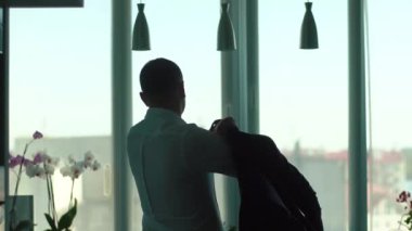 Takım elbise ceket giyer ve pencereden bakarak işadamı arkadan görünüm.