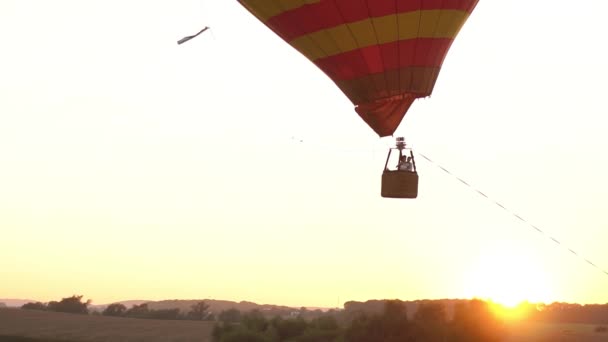 La composition du ballon d'atterrissage sur le terrain pendant le coucher du soleil. Le couple heureux vole dans l'aérostat . — Video