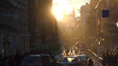 İnsanlar, arabaları ve trambuses gün batımı sırasında kalabalık şehir merkezi peyzaj görünümünü.