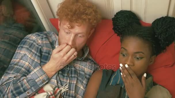 Schönes lächelndes Multi-Race-Paar, das sich per Handy Filme und Videos ansieht. das Porträt ihrer aufregenden Emotionen — Stockvideo