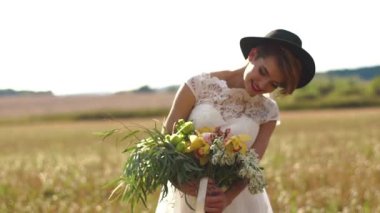 Güneşli alan arka plan, renkli çiçeklerle büyük buket gözlemleyerek gülümseyen sarışın kadın yatay portresi.