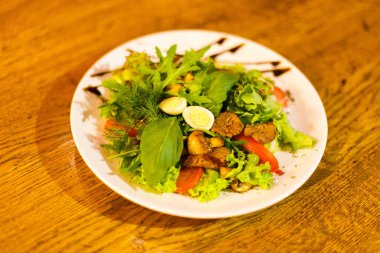 Salata yan görünüm oluşan maydanoz, EGUN, domates, et ve roka ve kahverengi sos ile dekore edilmiş.