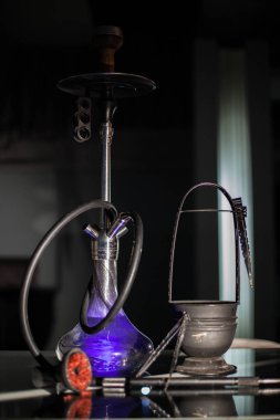 Mor shisha tüm aksesuarları ile birlikte komple bir koyu arka plan üzerine yerleştirilen.