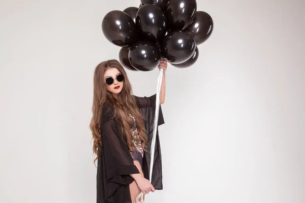 Georgeous meisje met lang haar en rode lippen dragen van bril en combinatie poseren voor de camera met een bundel van baloons. — Stockfoto