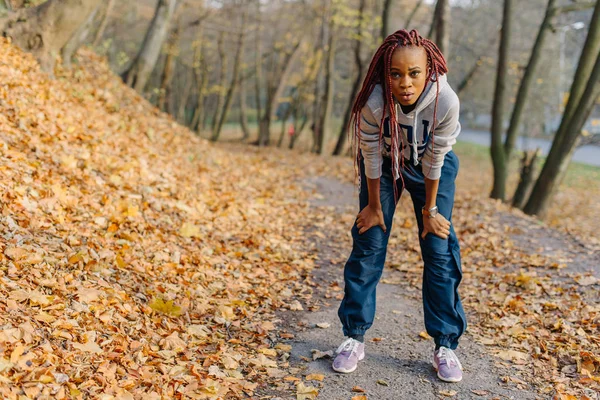 Mujer bonita atractiva afroamericana después de correr en el parque. Otoño . — Foto de Stock