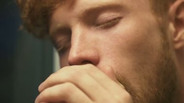 Sarışın kıvırcık saçlı ve akıntısı hasta adamın yüzünü burun, öksürük. Yakın çekim portre