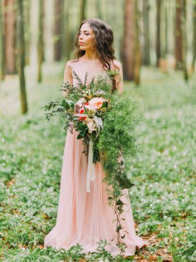 Hafif pembe elbise ayakta kadında yakın çekim dikey fotoğraf kırmızı ve beyaz çiçekler bahar ahşap büyük buket.