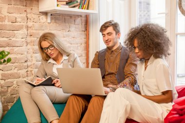 Güzel bir odada oturuyor ve birlikte çalışan üç genç sevgiyle.