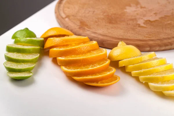 Assortment of cut fruits on a white table. — Stock Photo, Image