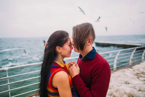 Lovers on the pier and seagulls at background. Romantic honeymoon — Stock Photo, Image