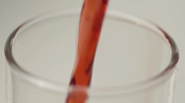 Yakın çekim yüksek cam doldurma kırmızı madde bakış. İçecek üstündeki kabarcıklar.