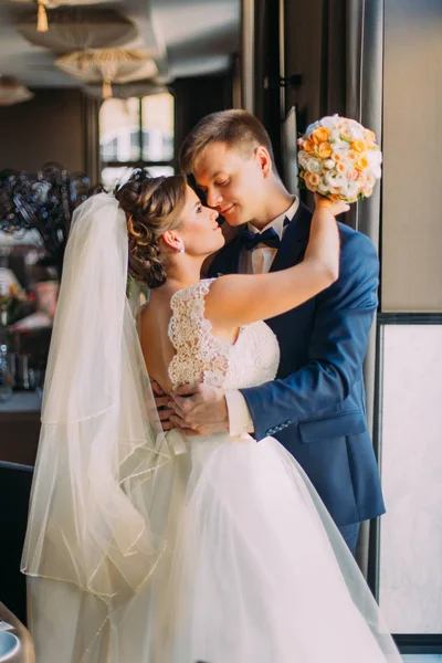 Ρομαντικό ζευγάρι ευτυχισμένο, γαμπρός φιλάει τη νύφη του κοντά σε παράθυρο κινηματογράφηση σε πρώτο πλάνο — Φωτογραφία Αρχείου