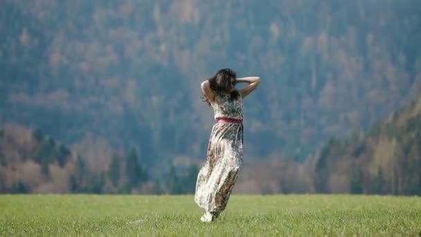 La mujer girando alrededor de las montañas cubiertas de árboles verdes . — Vídeos de Stock