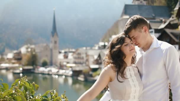 Le portrait sensible en gros plan du couple étreignant appuyé sur le pont à l'arrière-plan du vieux cirque placé dans les montagnes près de la rivière . — Video