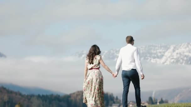 La belle promenade du couple sous le ciel nuageux dans les montagnes . — Video