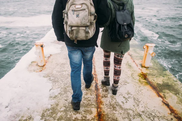 Gelukkige stijlvol paar wandelen op de oude pier in de wintervakantie. Reizen samen concept. Achtergrond van de zee — Stockfoto