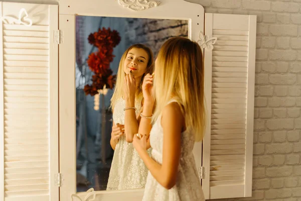 O reflexo da menina muito sorridente aplicando os lábios no espelho . — Fotografia de Stock