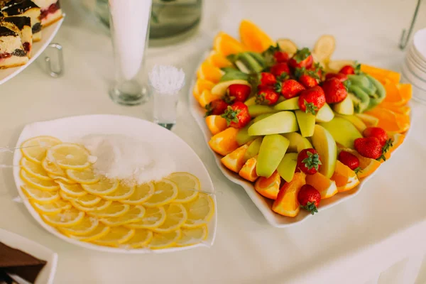 Die obige Ansicht der Fruchtkomposition bestand aus Erdbeeren, Äpfeln, Orangen, Zitronen, die auf den Hochzeitstisch gelegt wurden. — Stockfoto