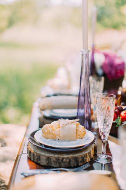 Kraft kağıt ve ip sarılmış ve arka plan yeşil orman ahşap standında yerleştirilen kruvasan ve yan dikey fotoğraf.