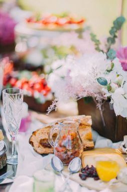 Düğün sofra bileşimi. Tablo ahşap tencerede, lezzetli peynir, ekmek, meyve kek ve kurutulmuş meyve güzel kokulu güzel çiçek dolu.