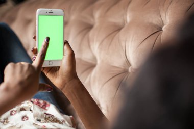 Kadının el ile yeşil perde telefon tutarak yakın çekim shot.