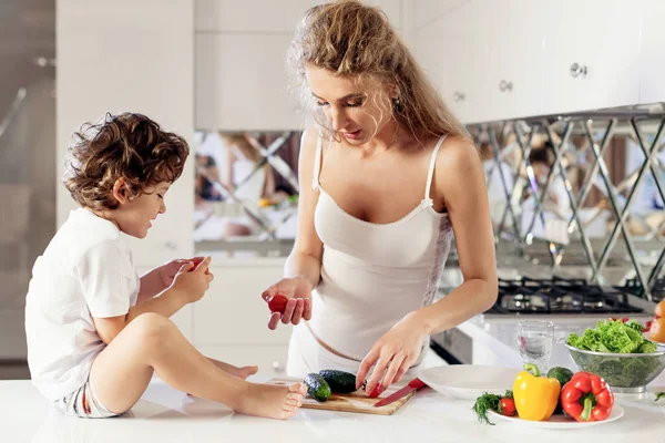 Anne ve küçük oğlu bir salata birlikte mutfakta yapma. — Stok fotoğraf