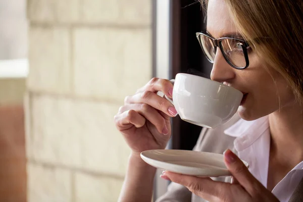 Портрет жінки, яка п'є каву з білої чашки. Жінка в окулярах . — стокове фото