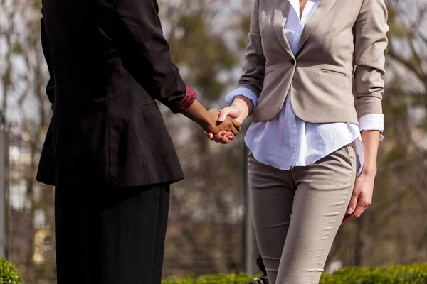 两个女企业家的西装与对方握手. — 图库照片