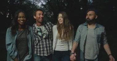 Sarılma ve eğlenerek mutlu çok kültürlü hipster arkadaş akşam walk.