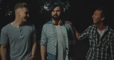 Neşeli hipster erkekler sarılma ve akşam parkta yürüyüş sırasında eğlenmek.