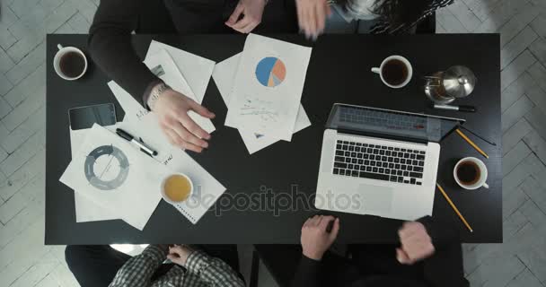 Los hombres de negocios juegan a las tijeras de papel y piedra. La vista anterior de la mesa cubierta con gráficos y portátil . — Vídeos de Stock