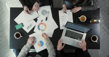 Yukarıdaki iş adamları solding grafikler, Çizelgeler kullanarak iş sorunları görüntüleyin. Adam dizüstü ekip için gösterilen.