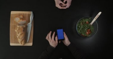 Ellerini mutfak masaya koy. Belgili tanımlık telefon perde kaydırma eller. Üstten Görünüm.