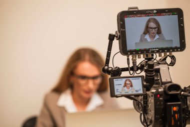 Ofiste iş kadını hakkında film yapmak bir kamera görüntüsünü kapatmak.