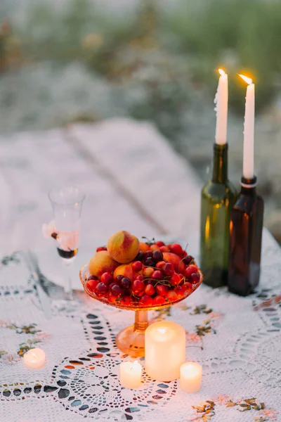 水果组成的特写垂直视图放在附近的闪亮的蜡烛在瓶. — 图库照片