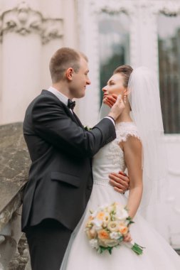 Gelin çiçekleri ile yüz sevişme damat yakın dikey görünümünü.