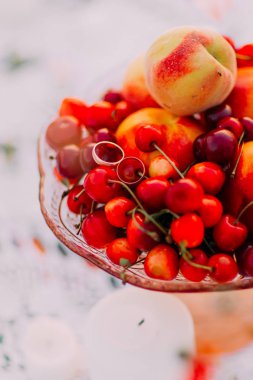 Altın alyans yerleştirilen meyve kompozisyon oluşuyordu vişne ve şeftali.