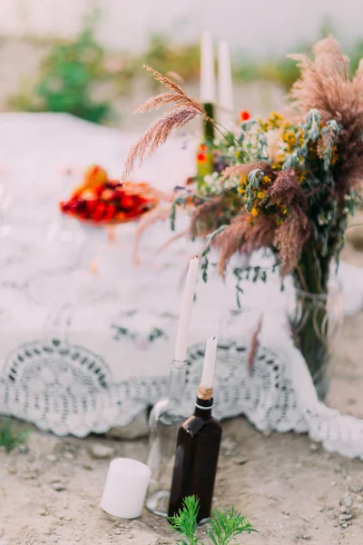 La composición de los cnadles en botellas y ramo de flores silvestres . — Foto de Stock