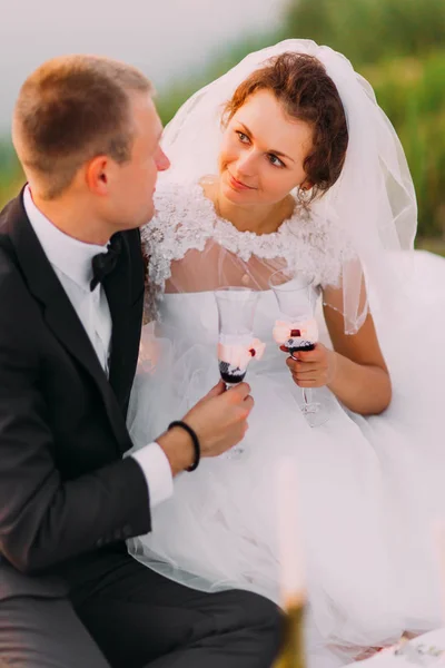 De glazen van de rammelende wijn van de bruid met de bruidegom. — Stockfoto