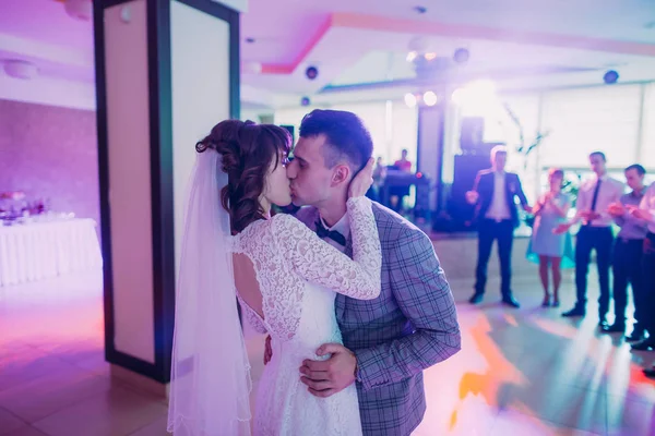 Os recém-casados beijando durante sua primeira dança no restaurante . — Fotografia de Stock