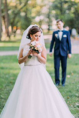 Gelin Damat Park arka plan bulanık, sarı buket tutarak yakından görmek.