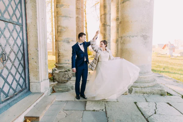 La pareja de bailarines recién casados cerca de la antigua iglesia gótica . — Foto de Stock