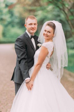 Parkta elele mutlu sarılma yeni evliler dikey görünüm.