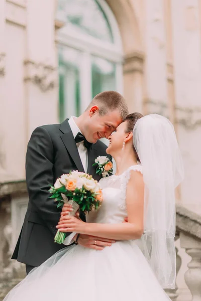 The sensitive side portrait of the smiling newlyweds standing head-to-head. — Stock Photo, Image